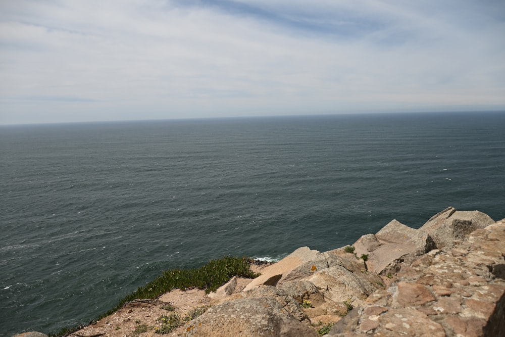 a large body of water sitting next to a rocky cliff