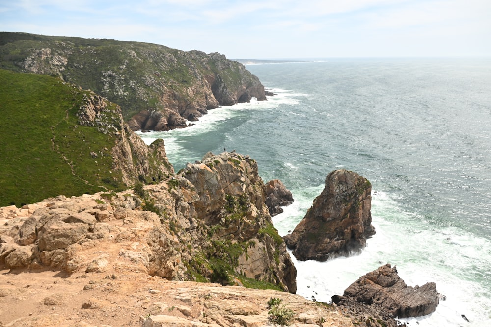 a large body of water next to a rocky cliff