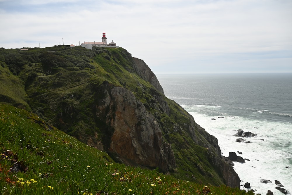 a lighthouse on a cliff overlooking the ocean