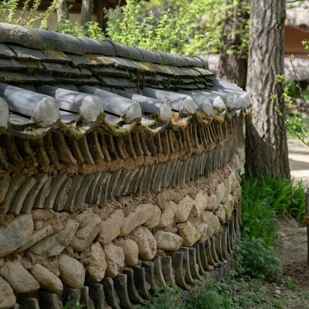 a stone wall with a wooden bench next to it