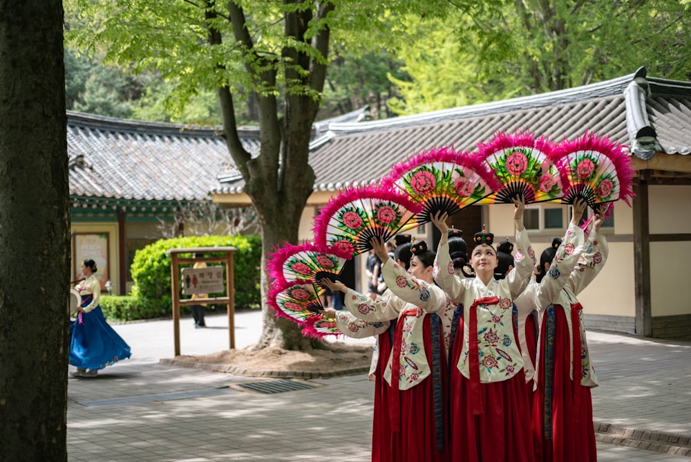 a group of women in traditional chinese dress holding parasols