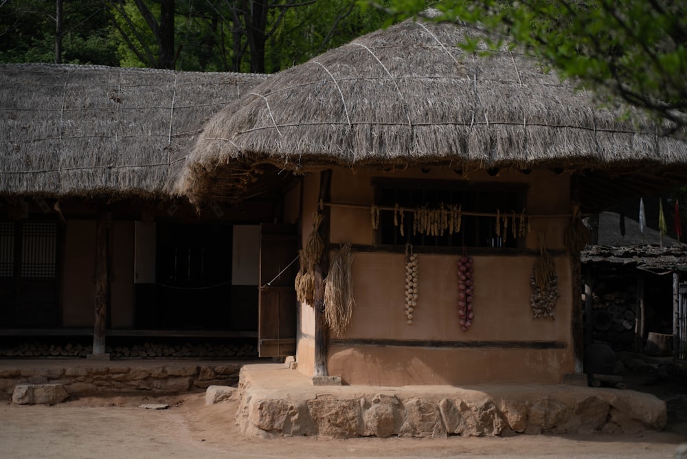 a hut with a thatched roof and stone steps