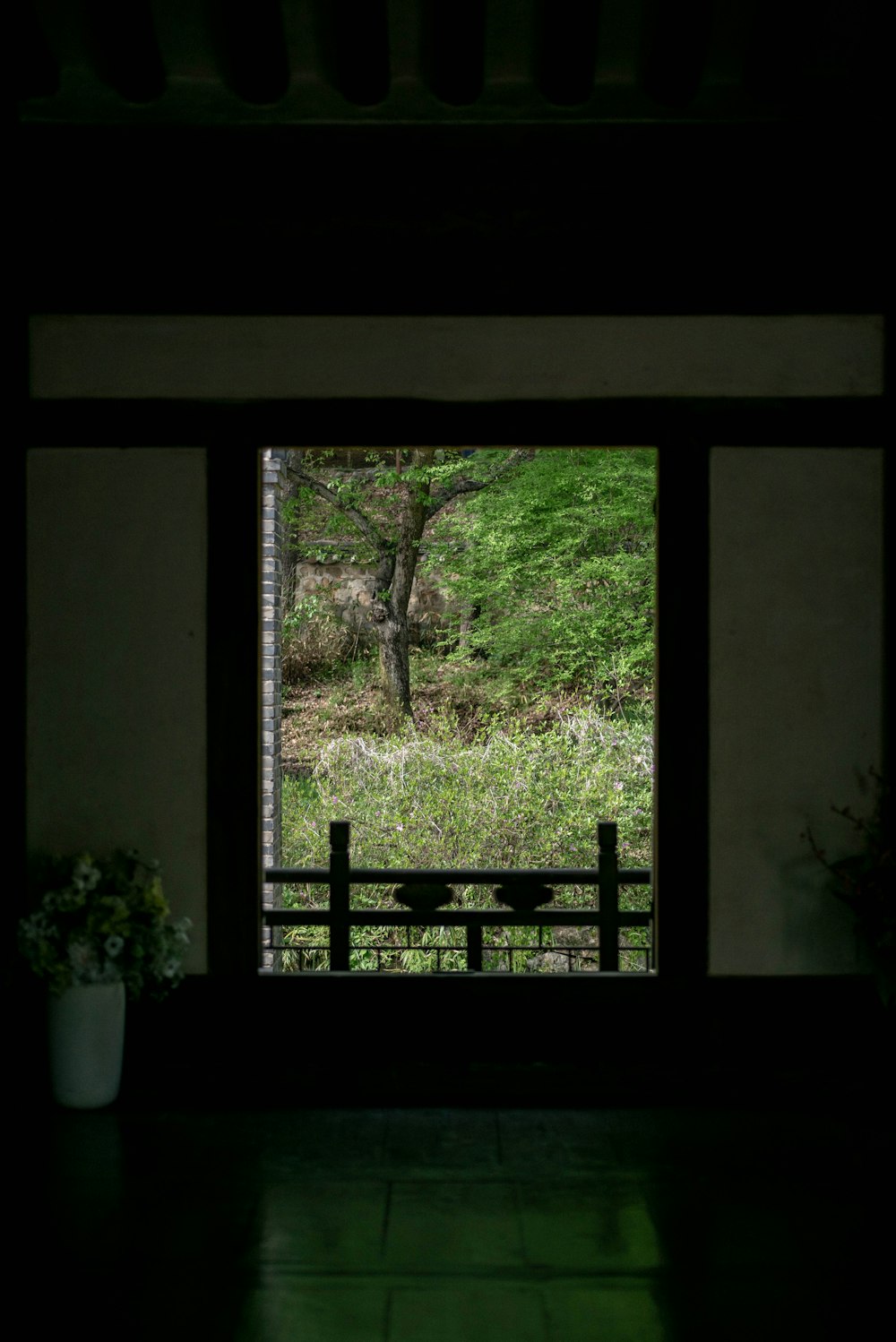 a dark room with a bench and a tree