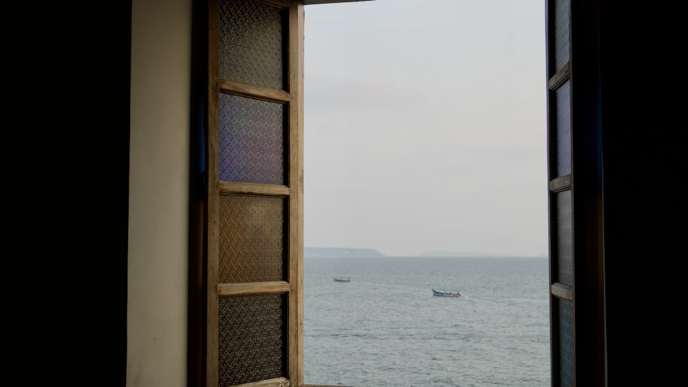 an open window with a view of the ocean