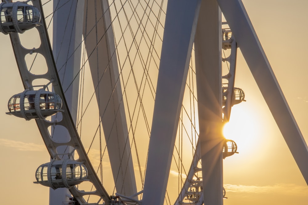 the sun is setting behind a large ferris wheel