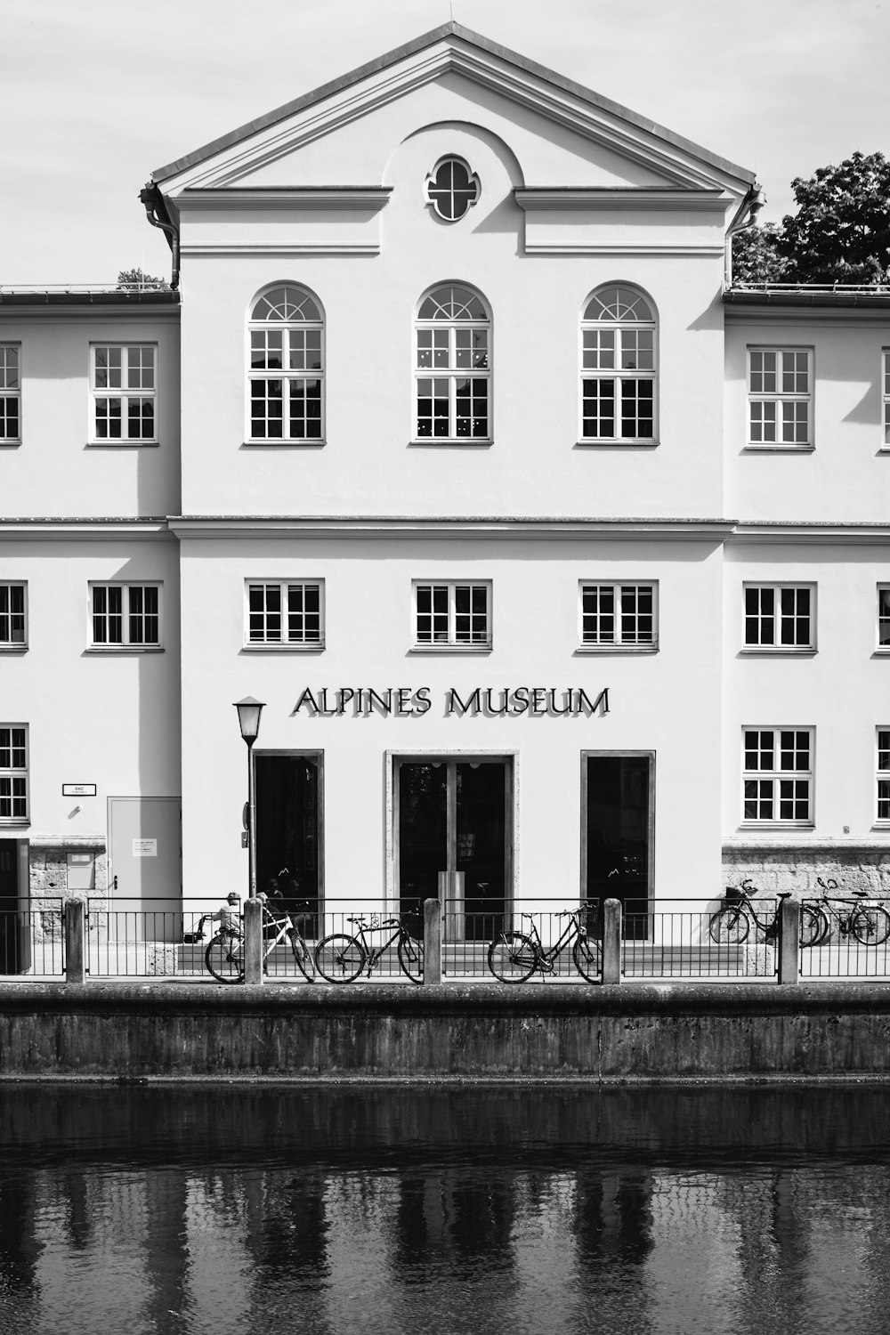 a black and white photo of a building with bikes parked outside