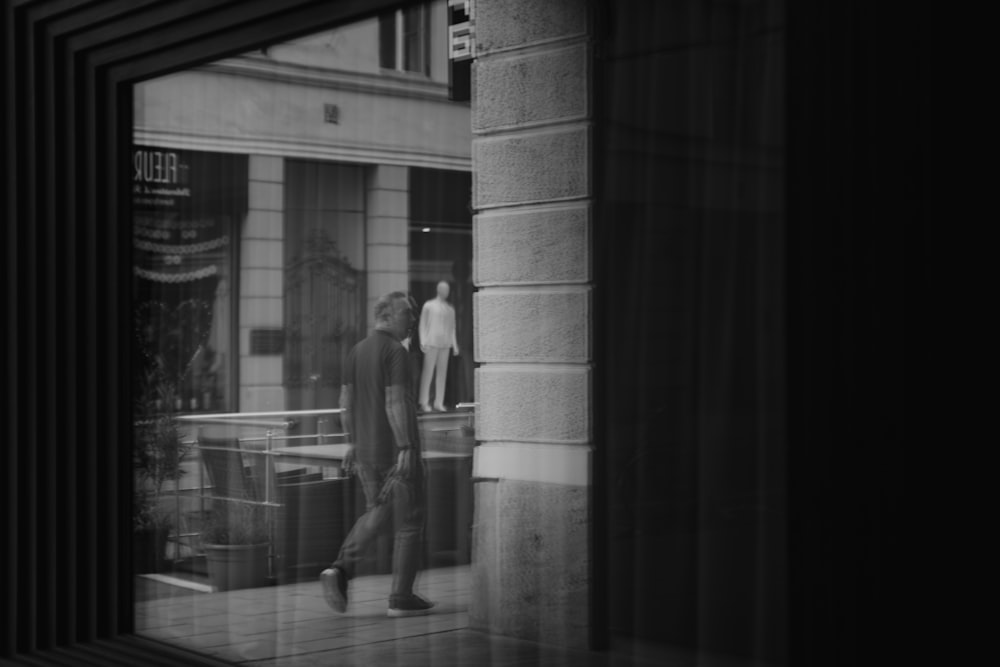 a couple of people walking down a street past a tall building