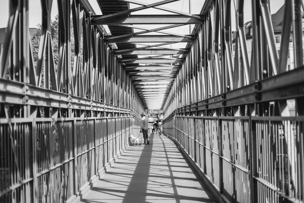 a black and white photo of people walking on a bridge