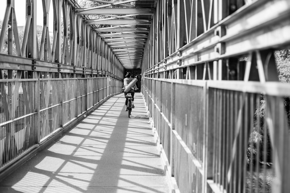 a person riding a bike across a bridge