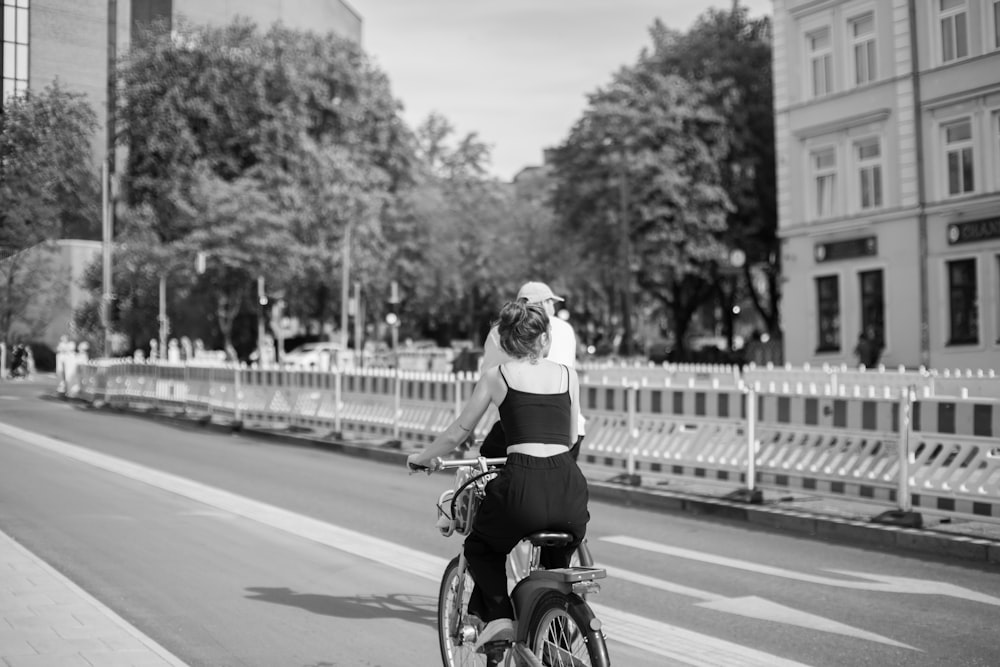 a woman riding a bike down a street