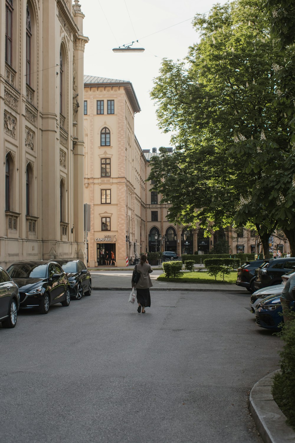 una donna che cammina lungo una strada accanto a edifici alti