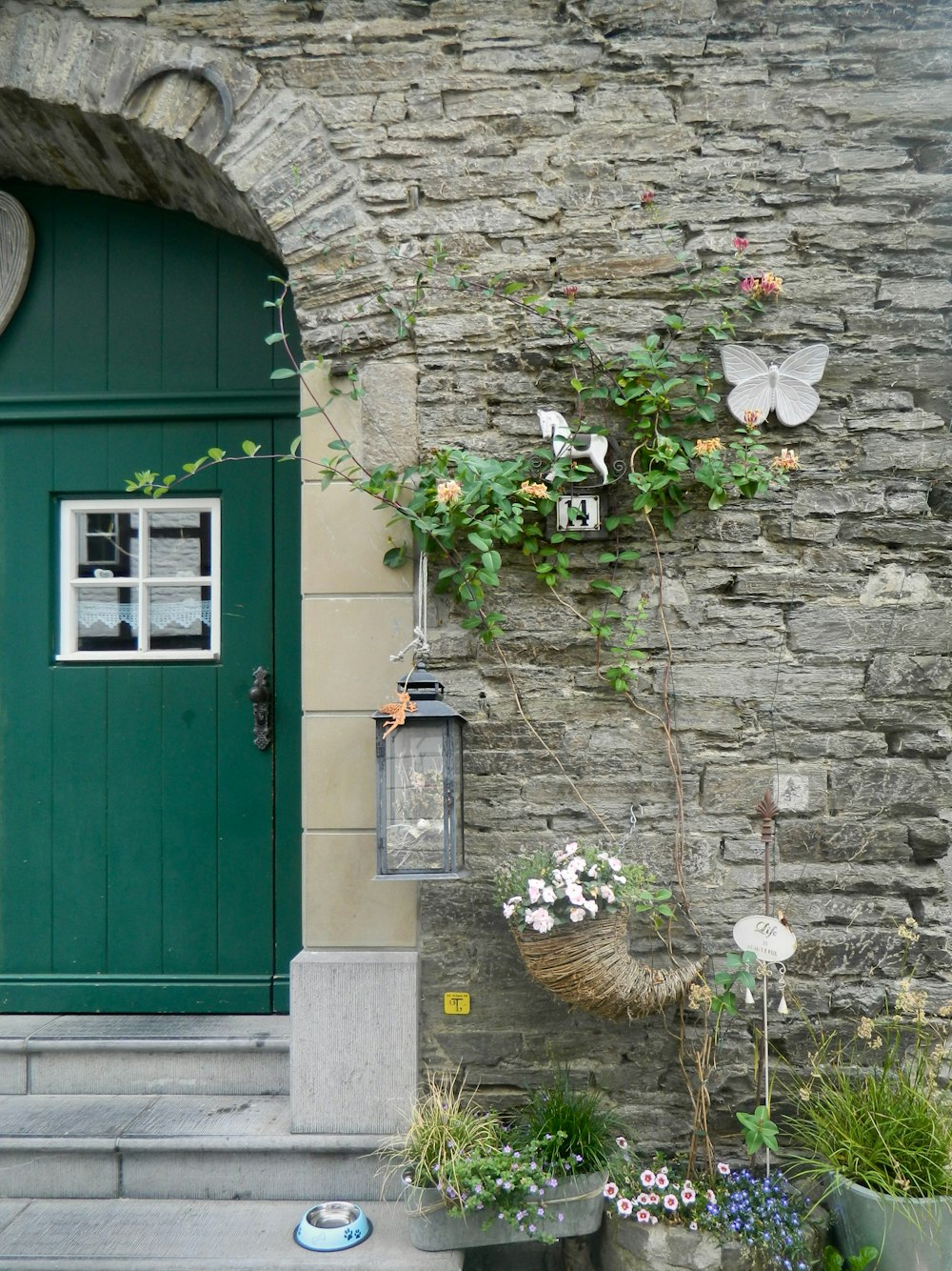a stone building with a green door and window