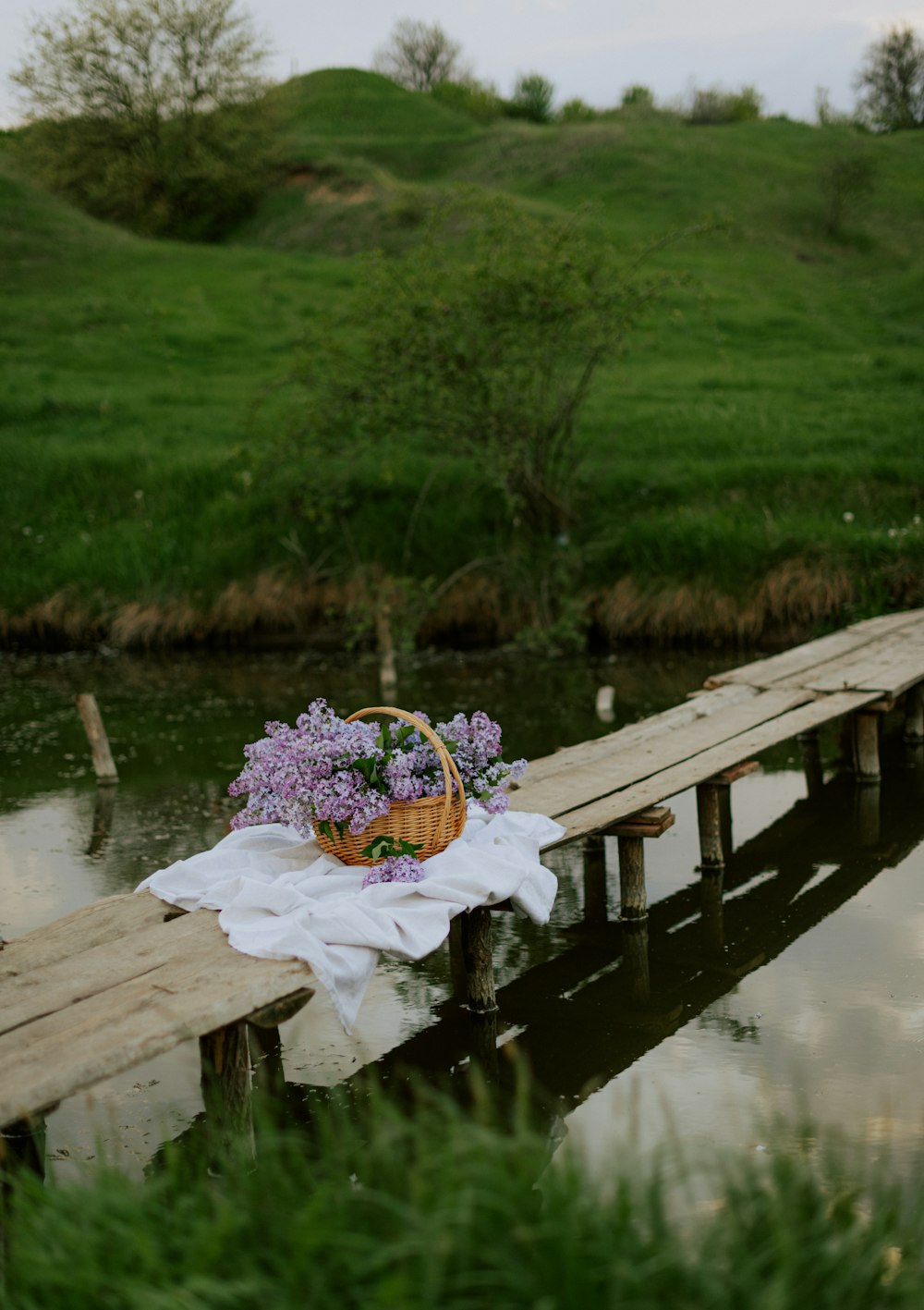 a basket of flowers sitting on a wooden dock