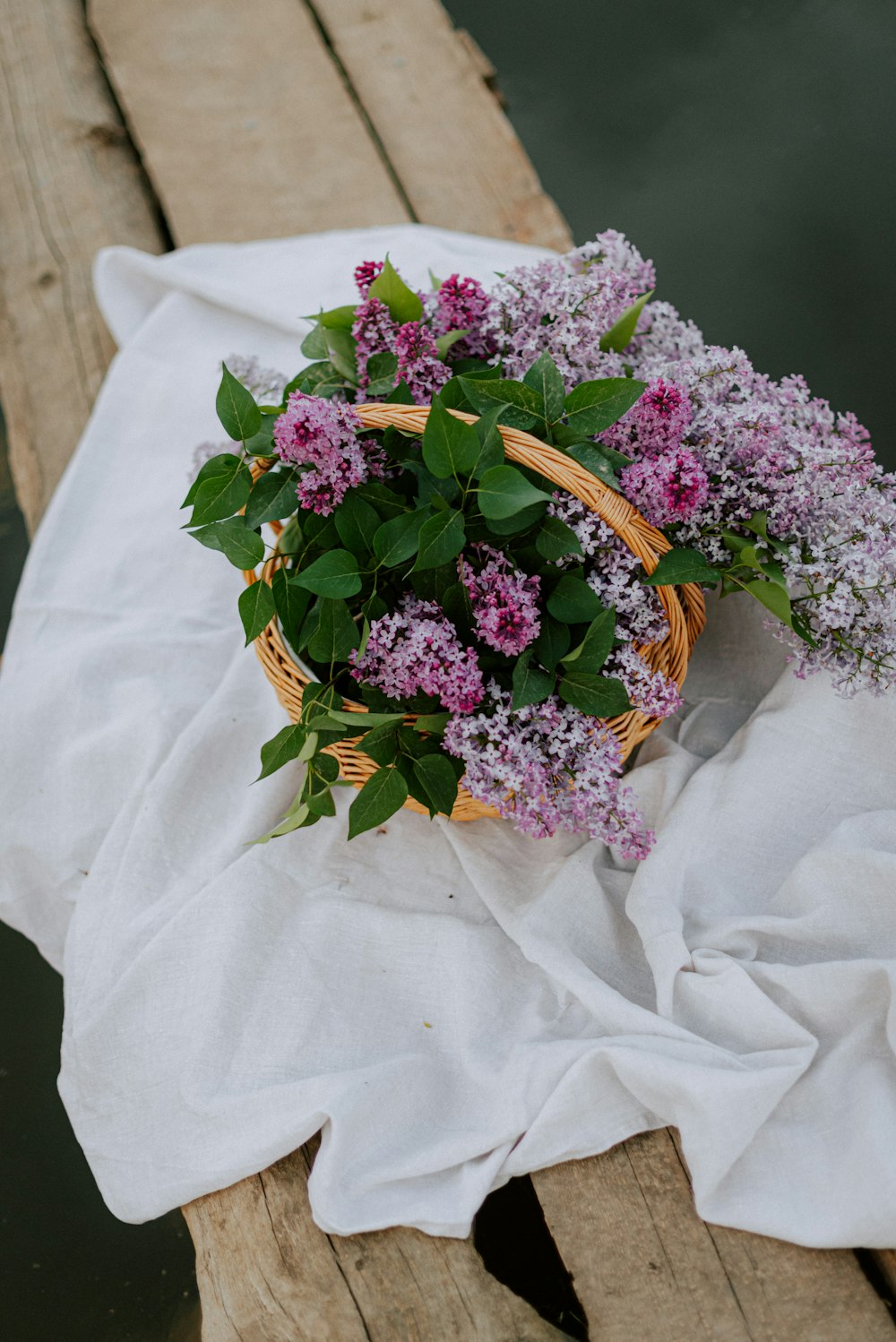 a basket of flowers sitting on top of a white cloth
