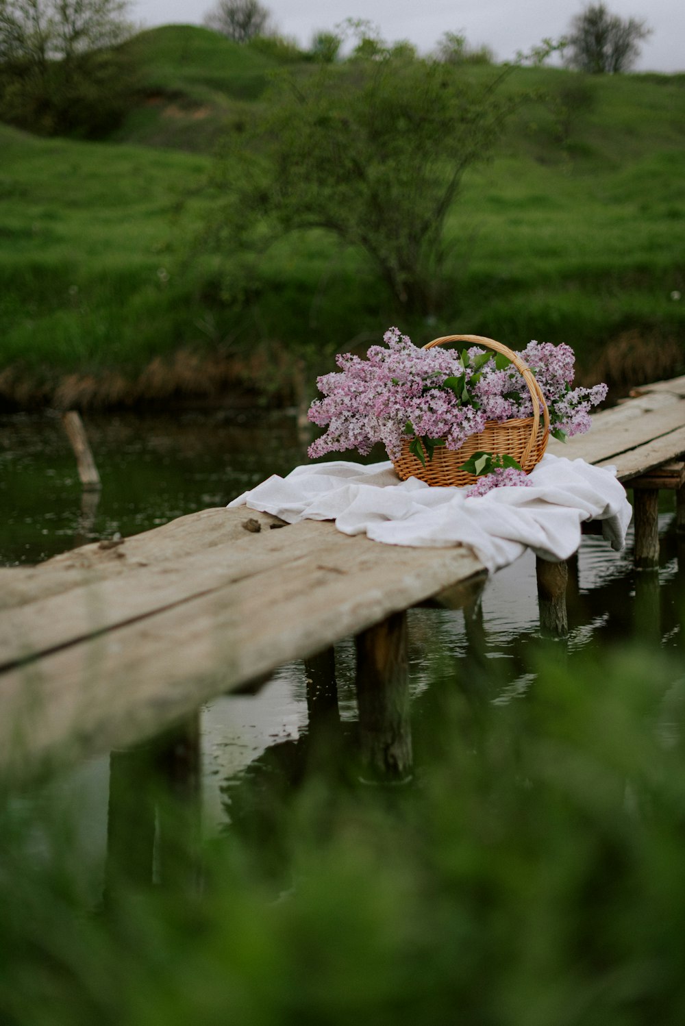 a basket of flowers sitting on a wooden dock