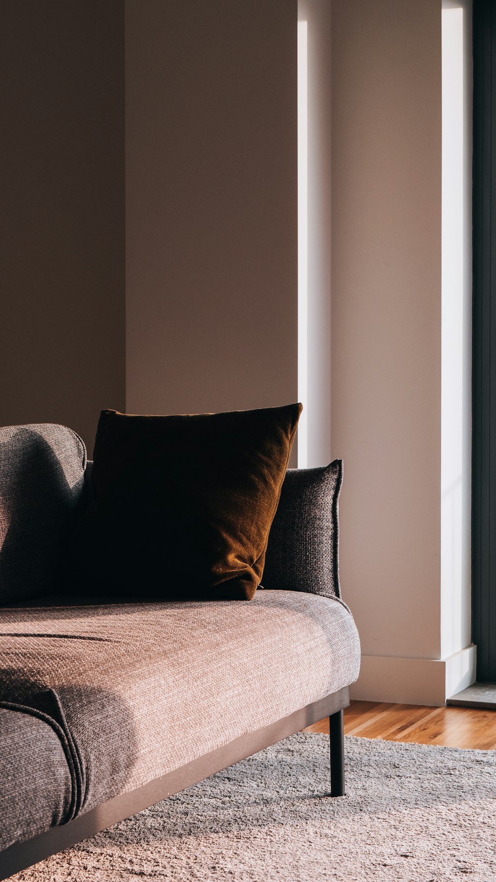 a couch sitting on top of a wooden floor next to a window