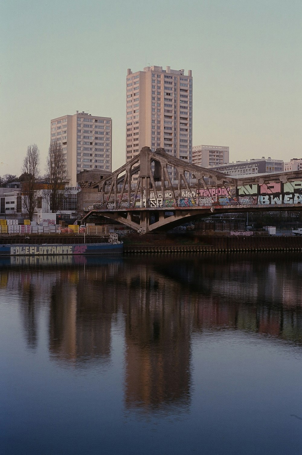 a bridge that has graffiti on it over a body of water