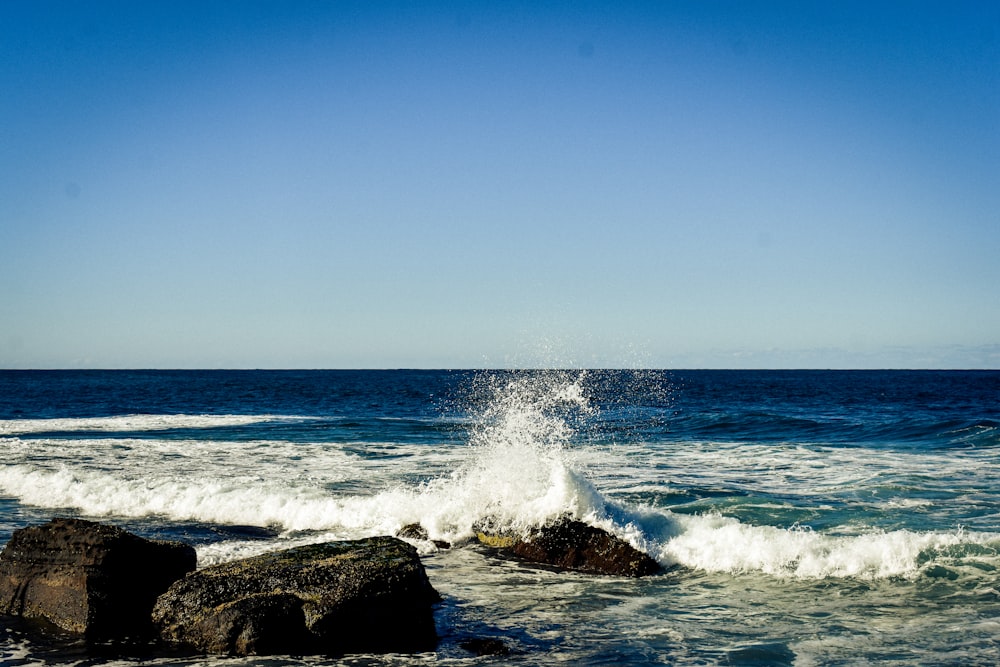 a wave hitting on rocks in the ocean