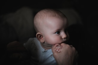 a baby in a white shirt is looking at something