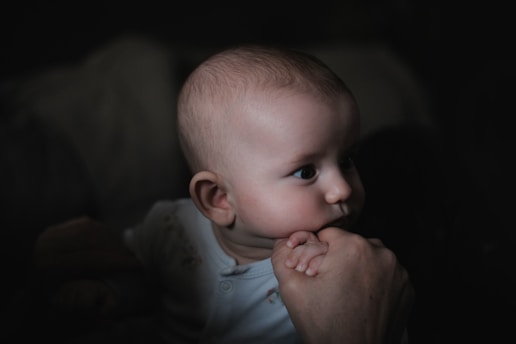 a baby in a white shirt is looking at something