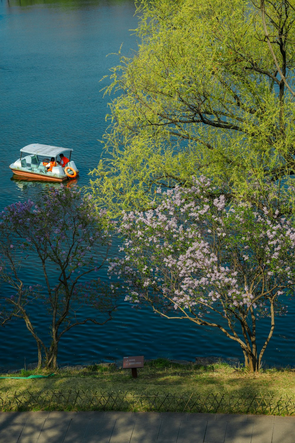 a boat floating on top of a lake surrounded by trees