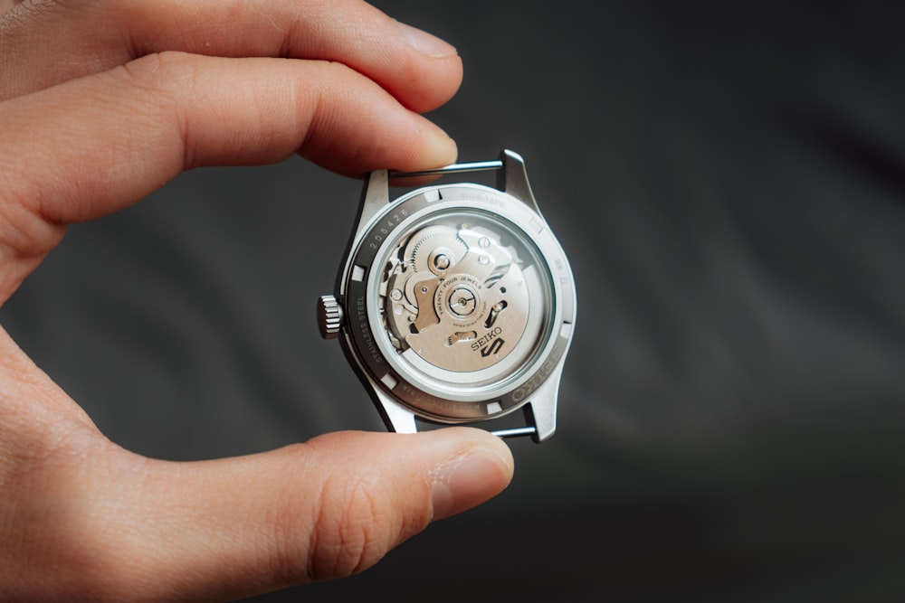 a person holding a watch in their hand