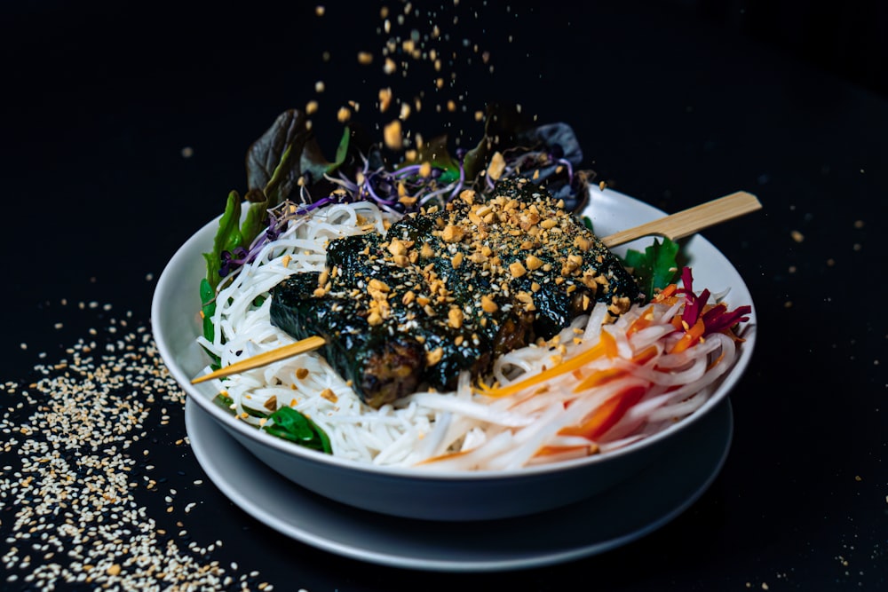 a bowl of food with chopsticks sticking out of it