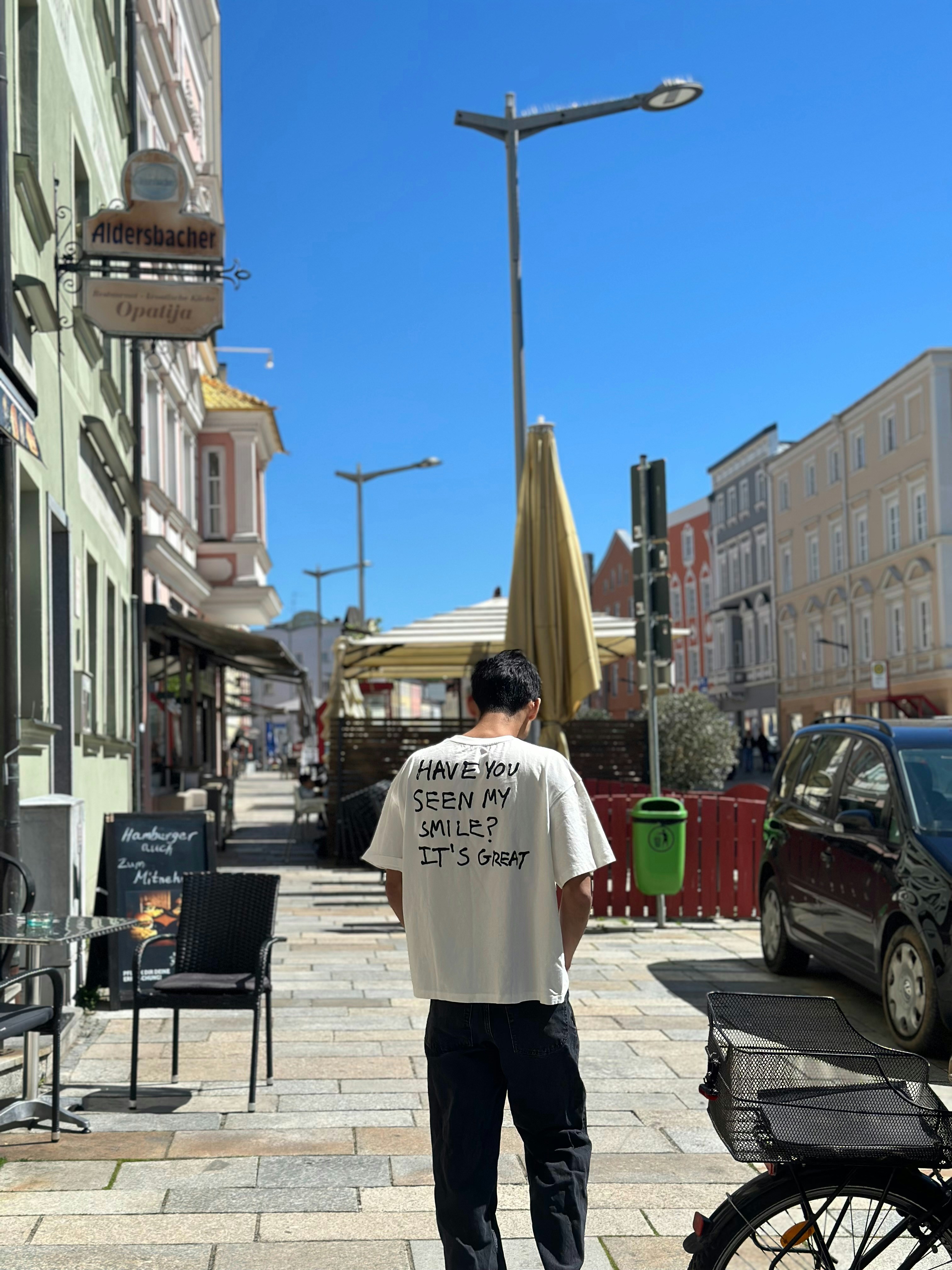 a man standing on a sidewalk next to a bike