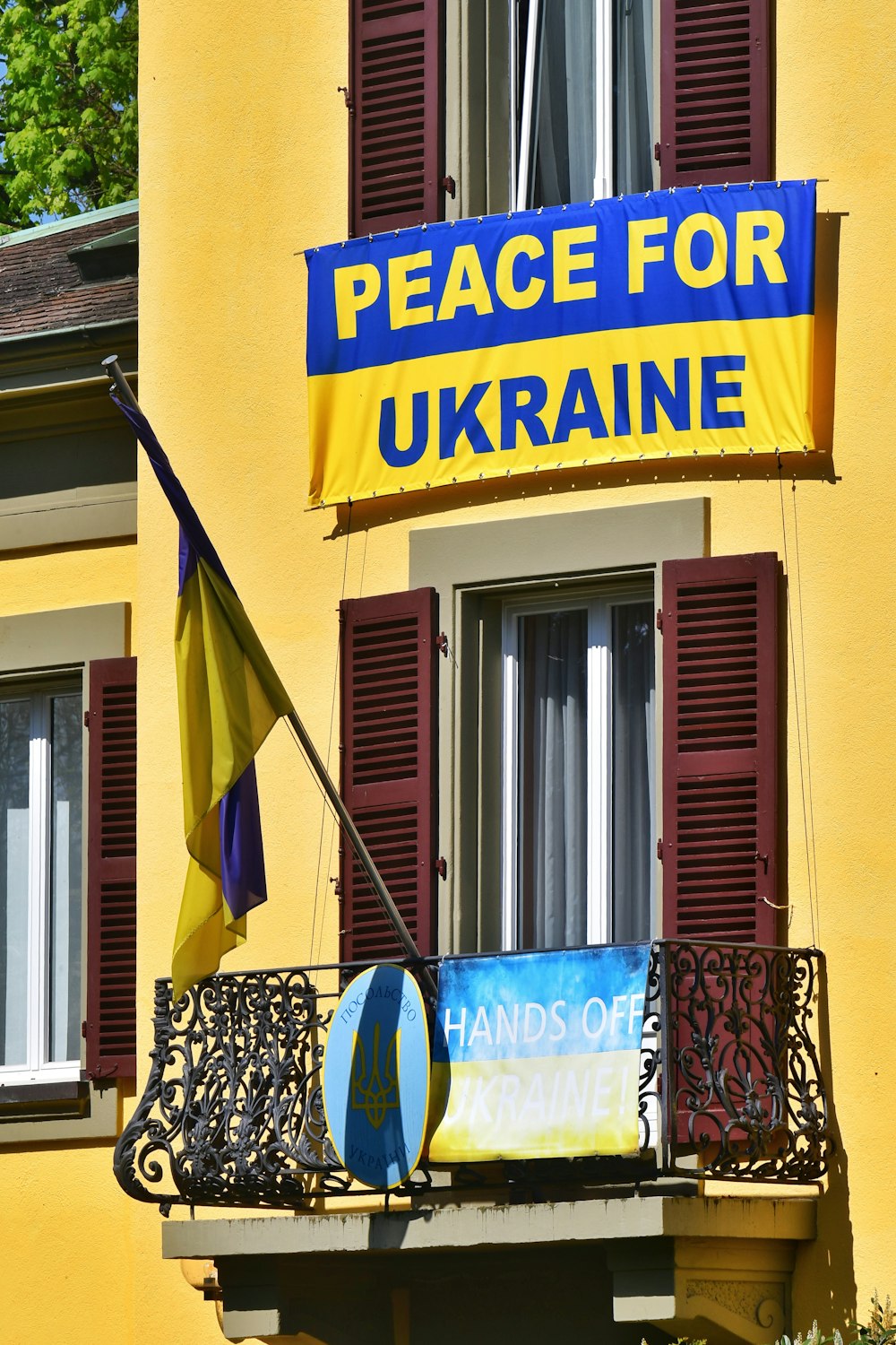a yellow building with a sign that says peace for ukraine