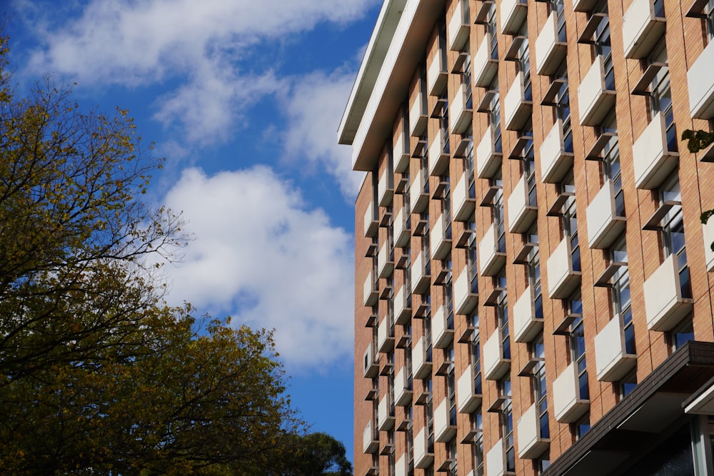 a tall brick building sitting next to a tree