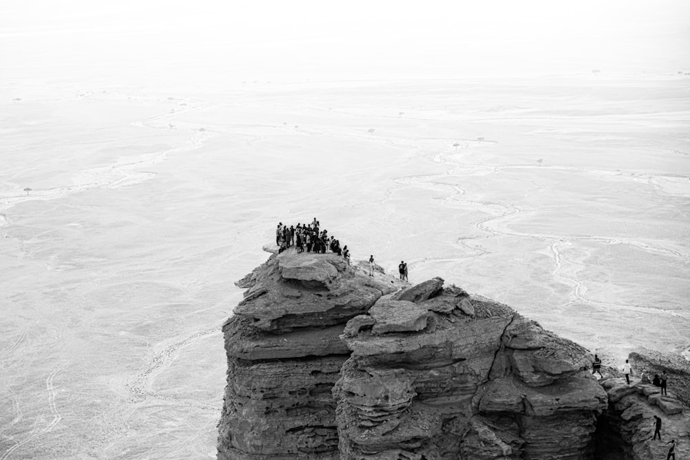 a group of people standing on top of a cliff