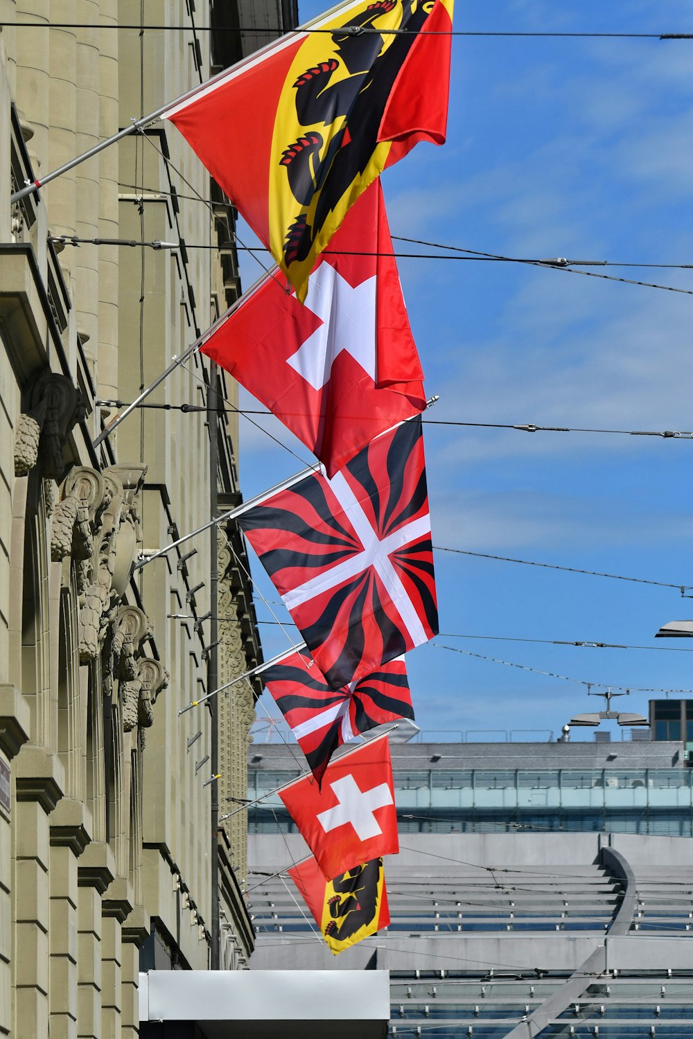 a group of flags hanging from the side of a building