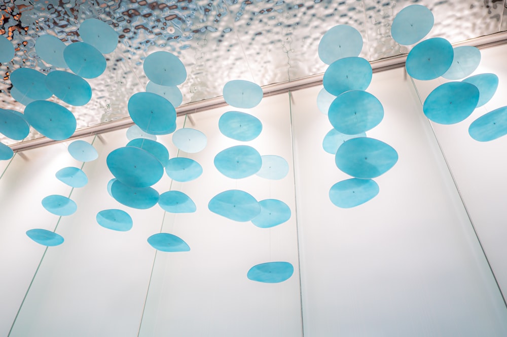 a bunch of blue balloons hanging from a ceiling