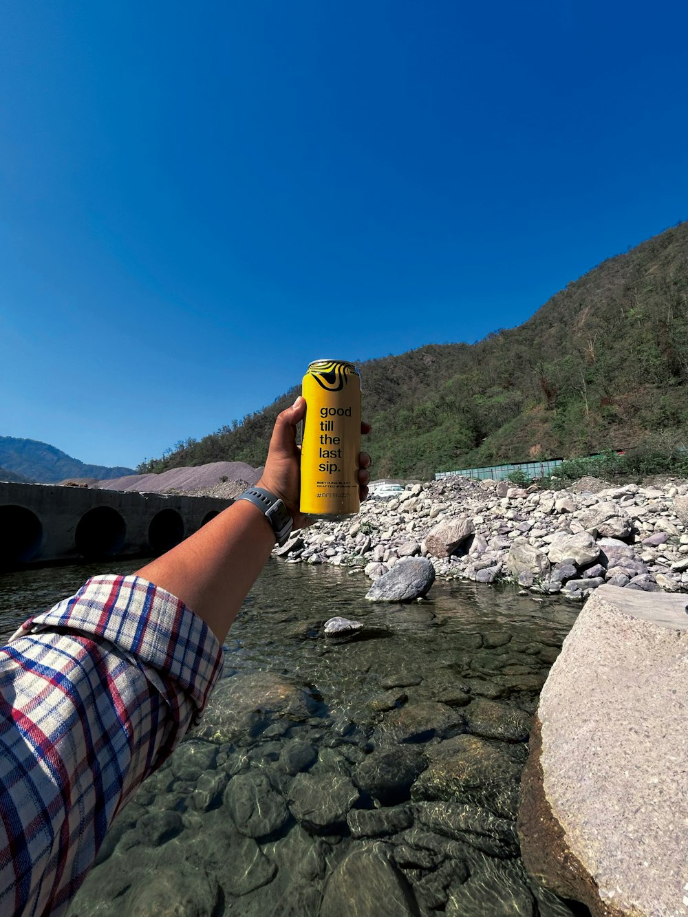 a person is holding a yellow bottle in the water