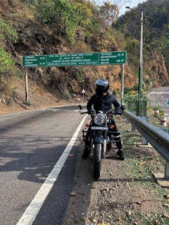 a man riding a motorcycle on the side of a road