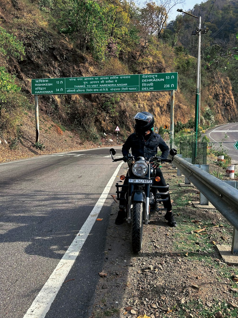 a man riding a motorcycle on the side of a road