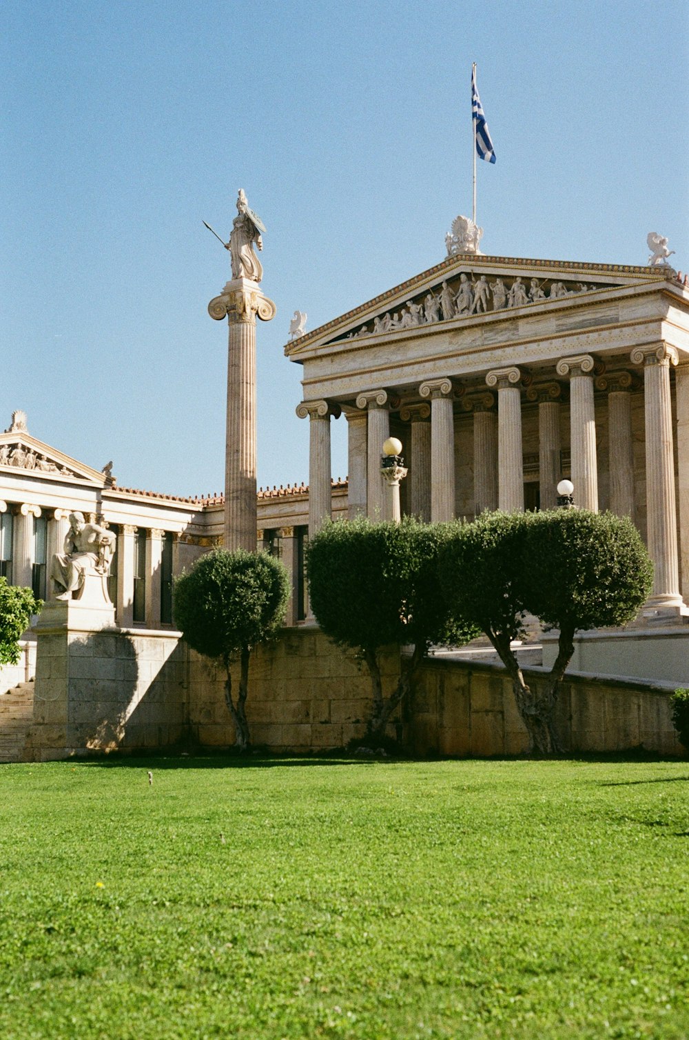 a building with columns and a statue in front of it