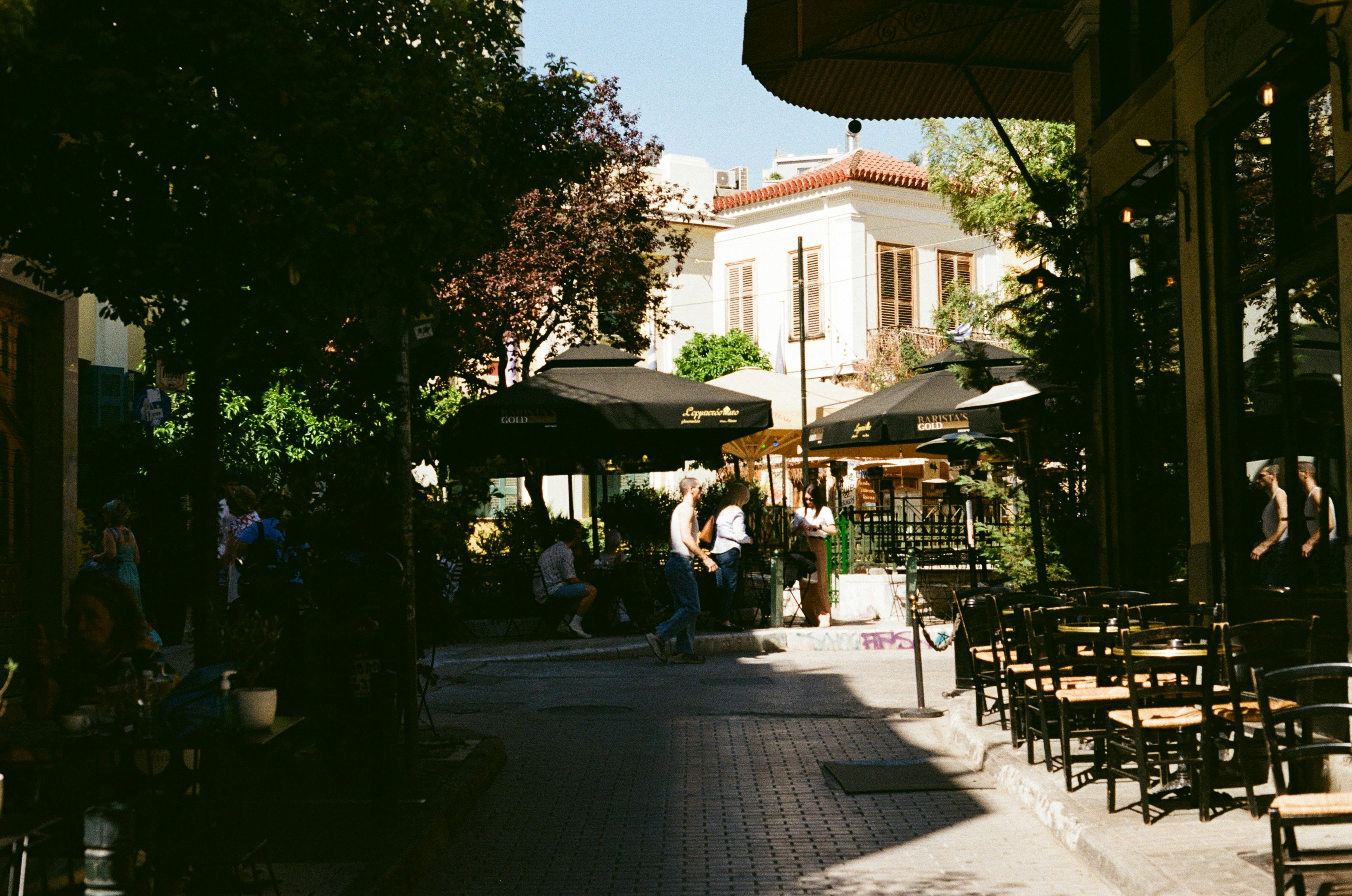 a group of people sitting at tables under umbrellas