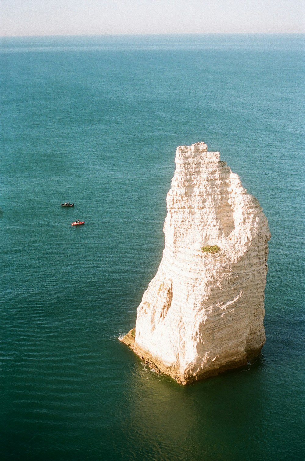ein großer weißer Felsen, der aus dem Meer ragt