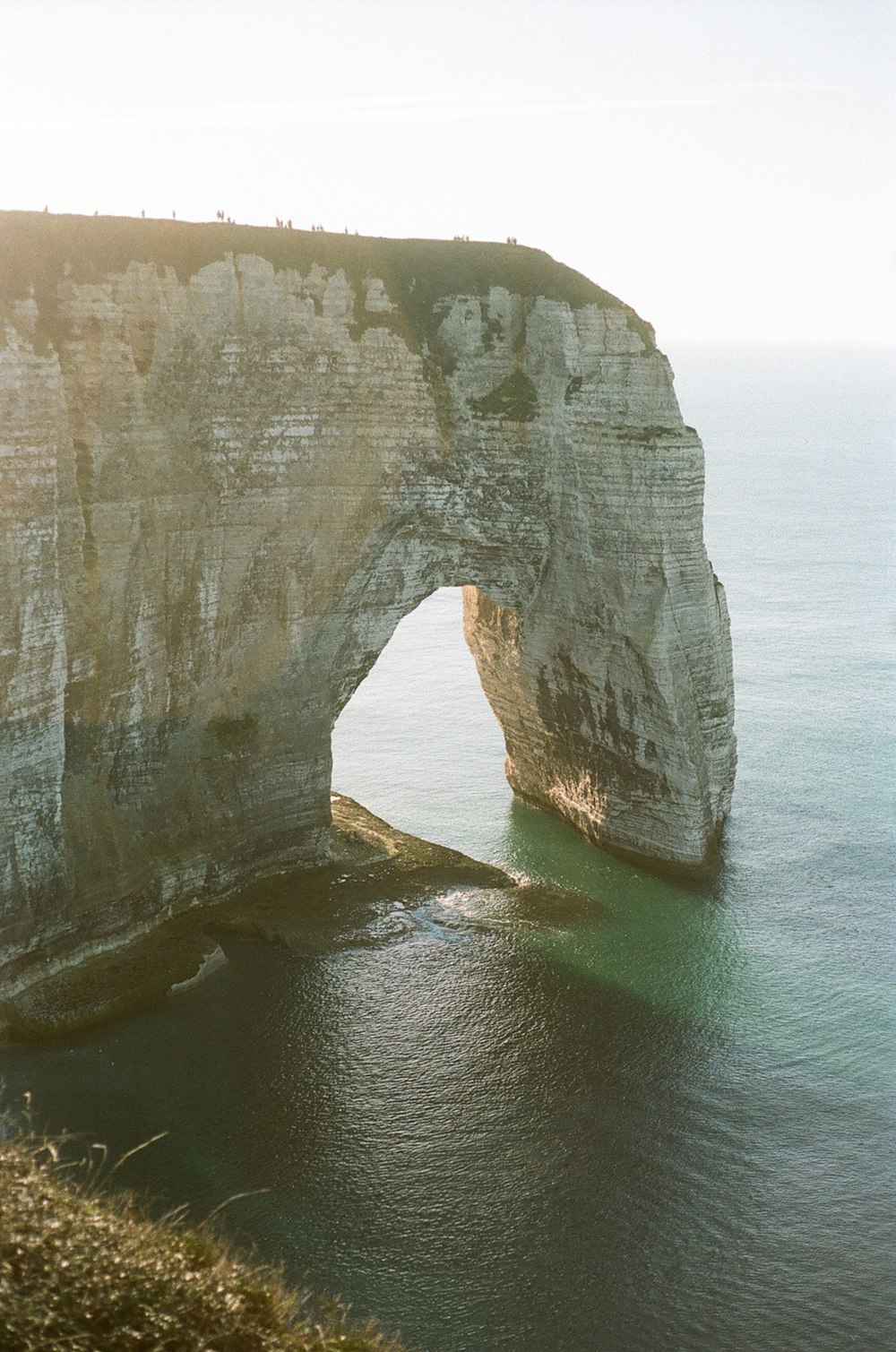 a large rock formation in the middle of a body of water