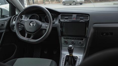 the interior of a car with a steering wheel and dashboard