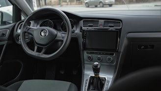 the interior of a car with a steering wheel and dashboard