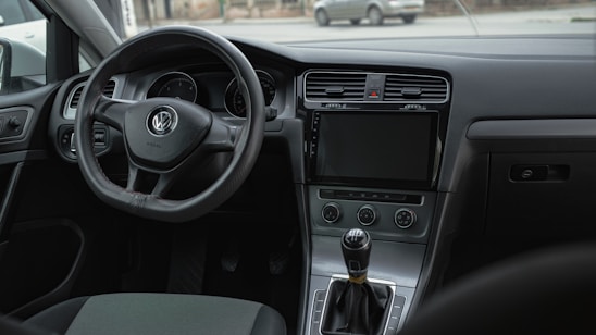 the interior of a car with a steering wheel and dashboard