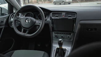 the interior of a car with a steering wheel and dashboard