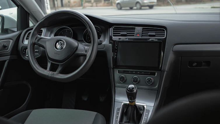 the interior of a car with a steering wheel and dashboard