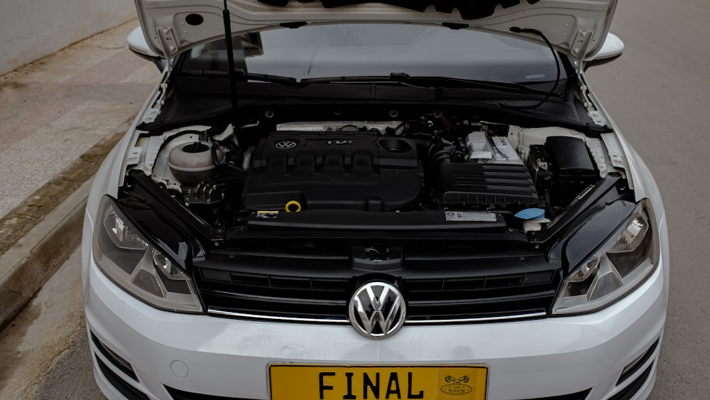 a white volkswagen car with its hood open