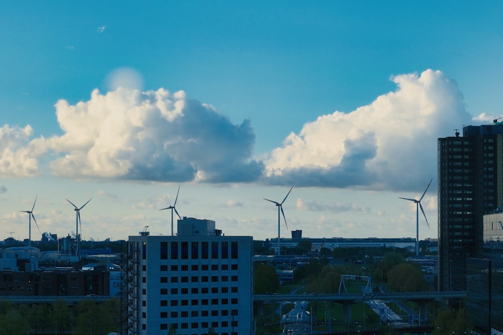 a view of a city with wind turbines in the background