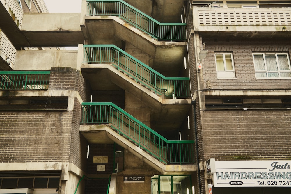 a tall building with balconies and green balconies