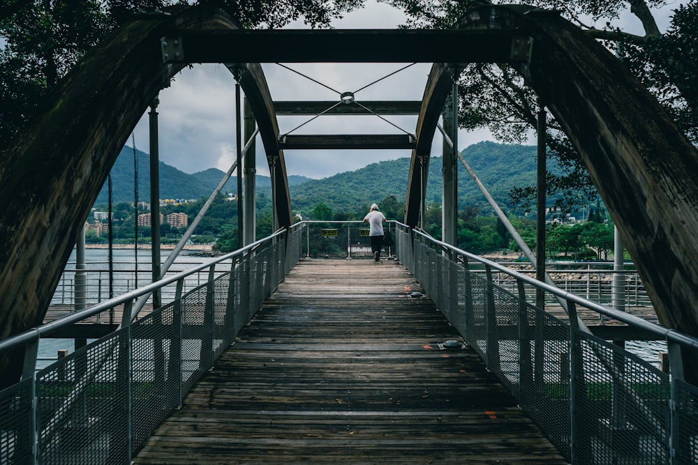 a person standing on a bridge over a body of water