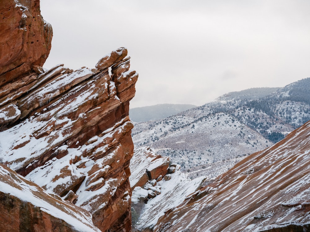 a rocky mountain with snow on the ground